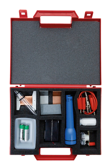 Das Bild zeigt einen roten Kasten, der mit Materialien für Experimente ausgestattet ist. Die enthaltenen Gegenstände umfassen eine Taschenlampe, Batterien, Kupferdrähte und verschiedene Verbindungsstücke, die für schulische Experimente verwendet werden können.