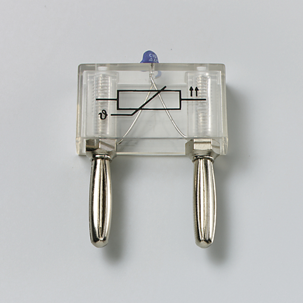 Ein transparenter Versuchsaufbau mit zwei metallischen Griffen und einer Drahtverbindung im Inneren wird gezeigt. Das Gerät dient vermutlich zur Durchführung elektrischer Experimente im Bildungsbereich.