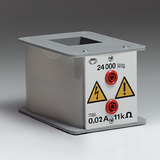 Ein graues Gehäuse mit einer quadratischen Öffnung an der Oberseite ist im Bild zu sehen, das zur Durchführung von Experimenten im Bildungsbereich dient. Es verfügt über verschiedene Anschlüsse und Warnsymbole, die auf elektrische Sicherheit hinweisen.