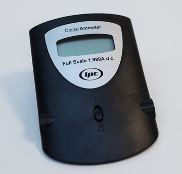 Ein digitaler Amperemeter ist abgebildet, der für die Messung elektrischer Ströme bis zu 1,999 Ampere DC ausgelegt ist. Er bietet ein einfaches Display zur Anzeige der Messwerte und ist in einem ergonomischen Design gestaltet.