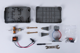 Die Abbildung zeigt eine Sammlung von Experimentiermaterialien, including Motoren, Schrauben und Kabel, die für den Bildungsbereich gedacht sind. Ein graues Gehäuse, Werkzeuge und diverse Komponenten deuten auf eine praktische Lernanwendung in der Technik oder Physik hin.