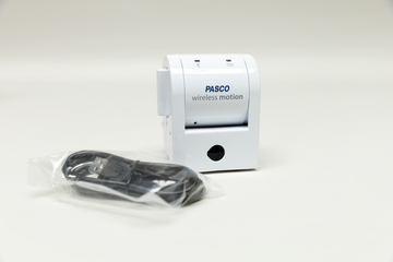Ein Wireless Motion Sensor in Weiß ist abgebildet, der für Experimentierzwecke genutzt wird. Neben dem Sensor liegt ein USB-Kabel in Plastikfolie verpackt.